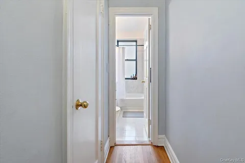 a bedroom with a bed wooden floor and window