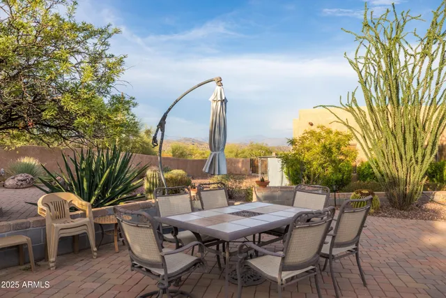 a kitchen with stainless steel appliances granite countertop a stove top oven a sink a stove a dining table and chairs