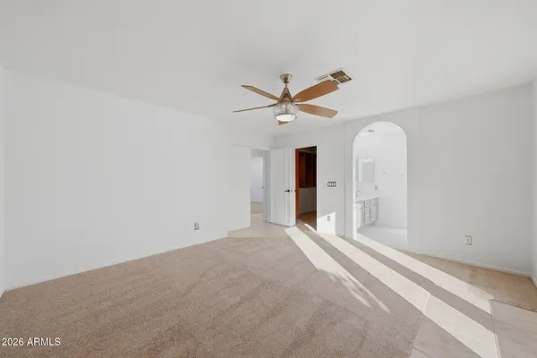 an empty room with closet and ceiling fan