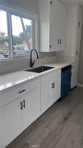 a kitchen with stainless steel appliances cabinets a sink and a large window