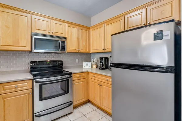 a kitchen with granite countertop cabinets stainless steel appliances and a window