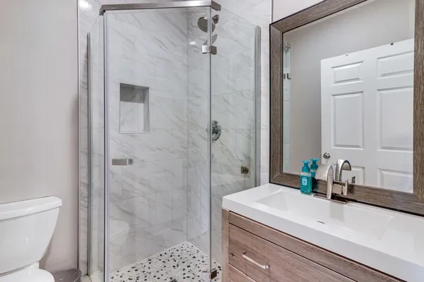 a bathroom with a sink a toilet and shower