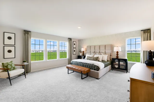 a spacious bedroom with a bed and a couch next to a window