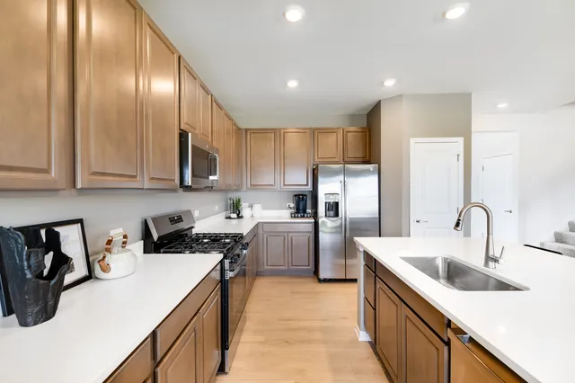 a kitchen with sink a refrigerator and cabinets
