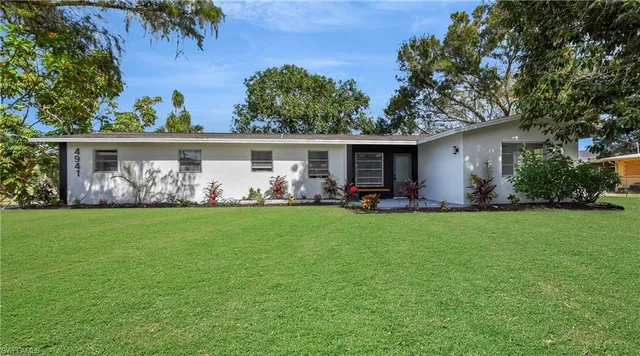 a front view of house with yard and outdoor seating