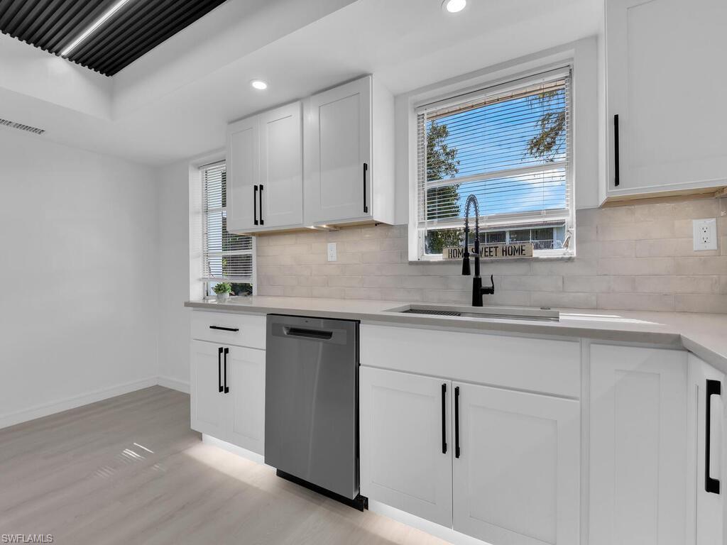 4941 Aztec Circle Naples, FL 34112 - Photo 14 of 36 a kitchen with stainless steel appliances white cabinets and a sink