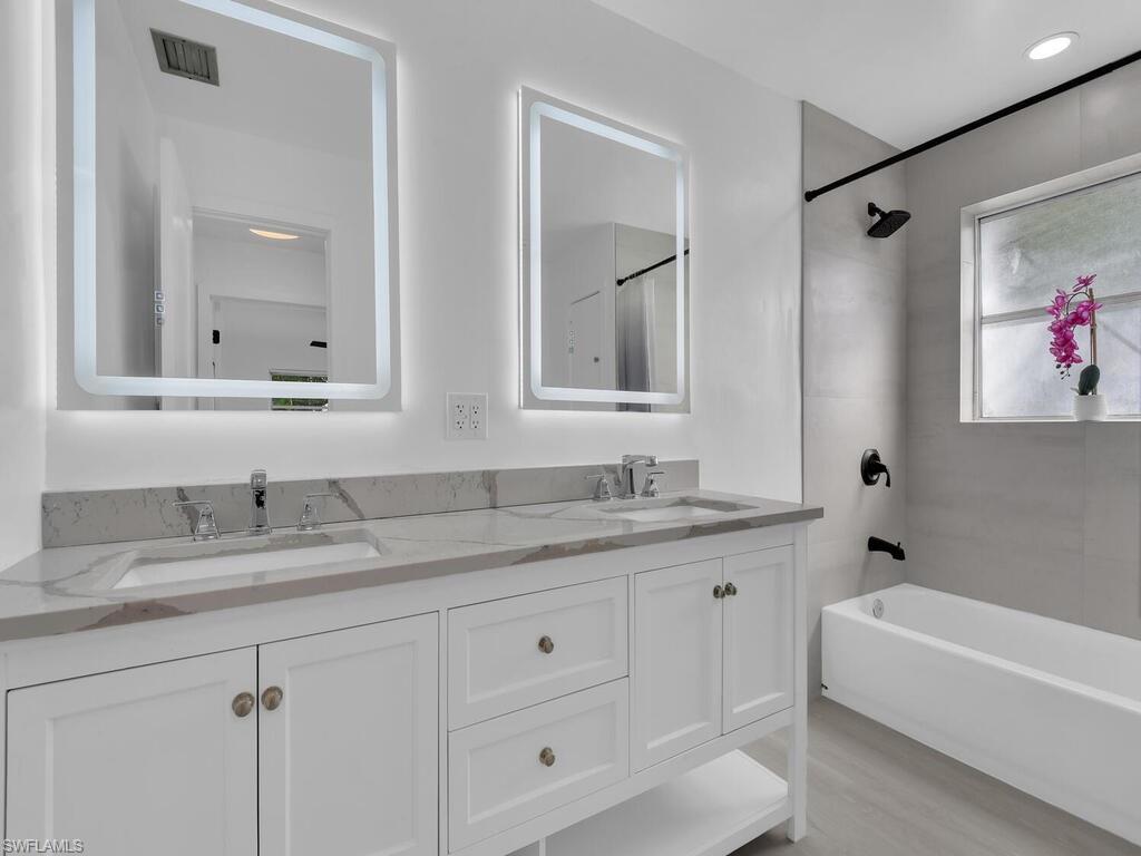 4941 Aztec Circle Naples, FL 34112 - Photo 23 of 36 a bathroom with a granite countertop sink mirror and bathtub