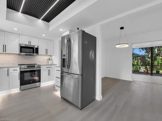 a kitchen with a refrigerator and a stove top oven