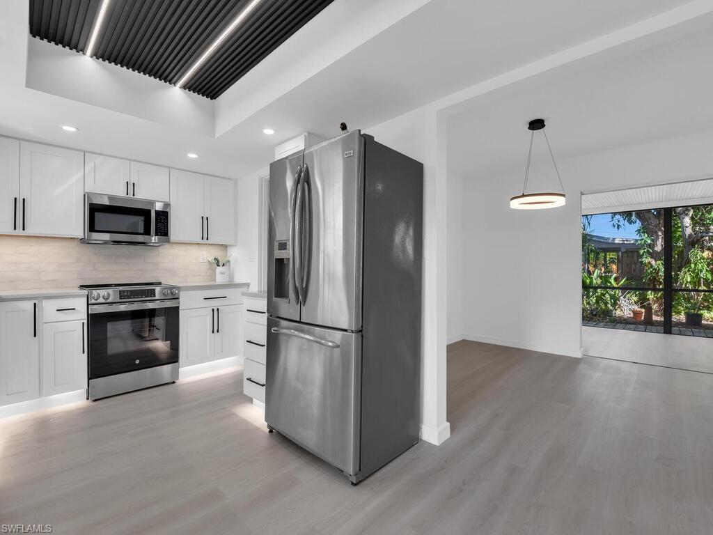 4941 Aztec Circle Naples, FL 34112 - Photo 3 of 36 a kitchen with a refrigerator and a stove top oven