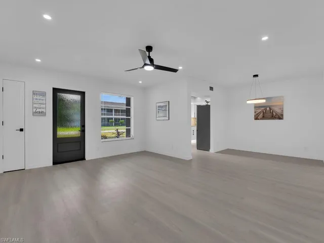 a view of a livingroom with a ceiling fan window and hardwood floor