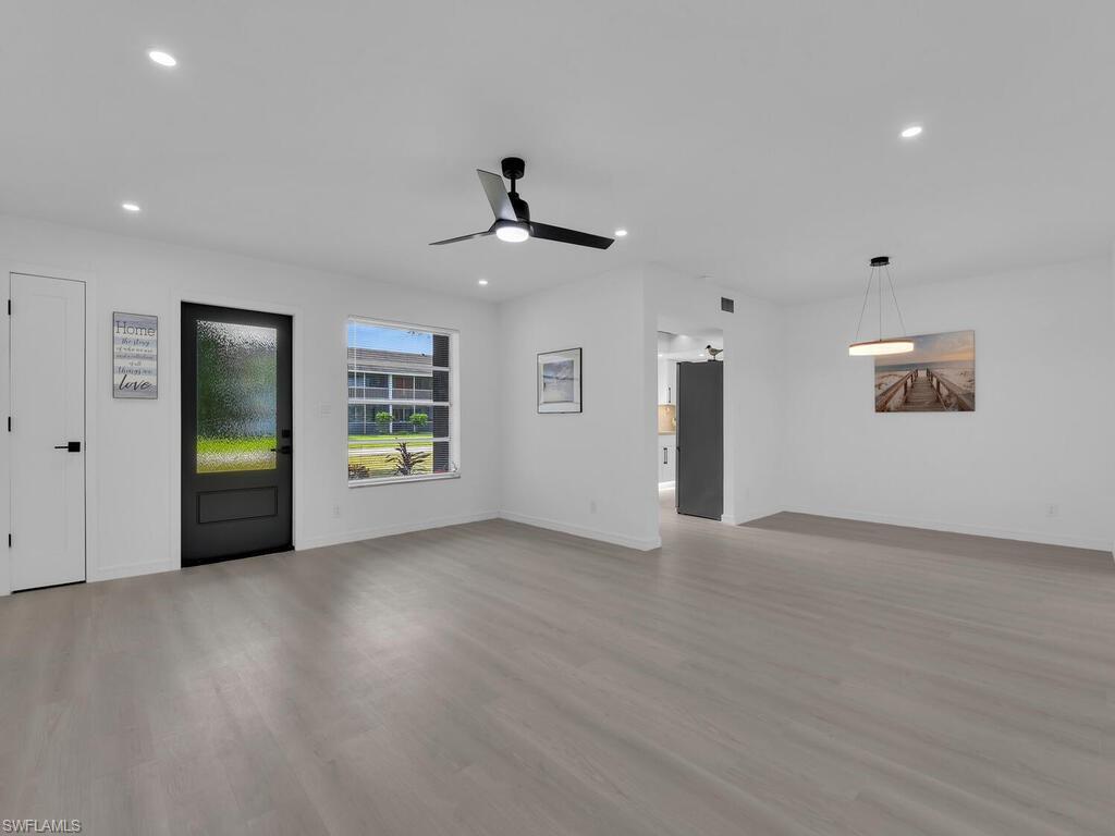 4941 Aztec Circle Naples, FL 34112 - Photo 5 of 36 a view of an empty room with a window and wooden floor