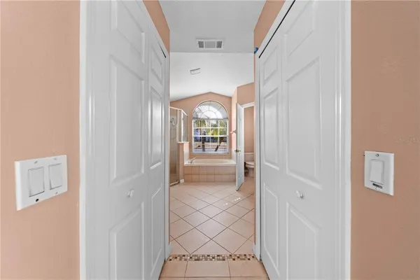 a view of a hallway view with wooden floor and a bathroom