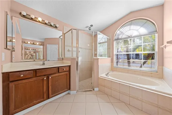 a spacious bathroom with a tub sink and mirror