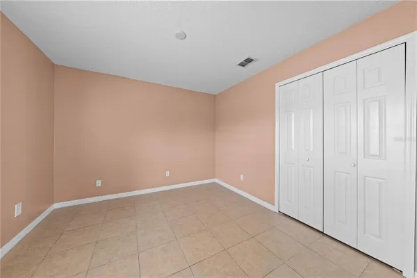 a view of an empty room with window and a bathroom