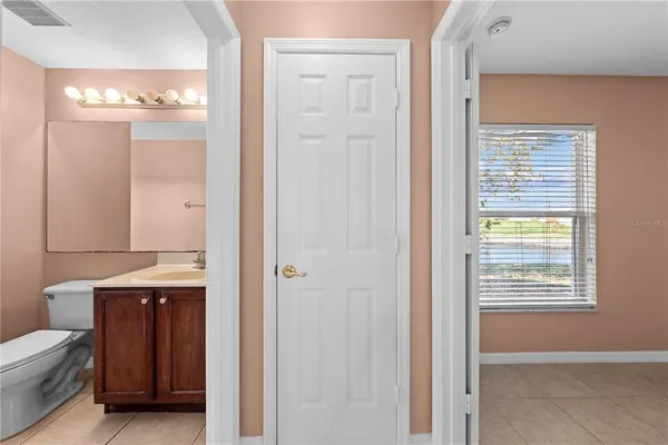 a view of an empty room with window and closet area