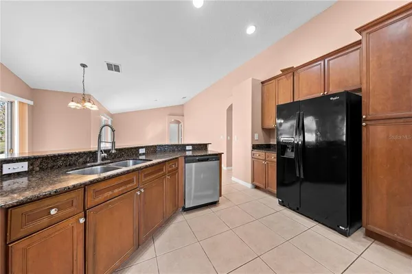 a kitchen with stainless steel appliances granite countertop a refrigerator and a sink
