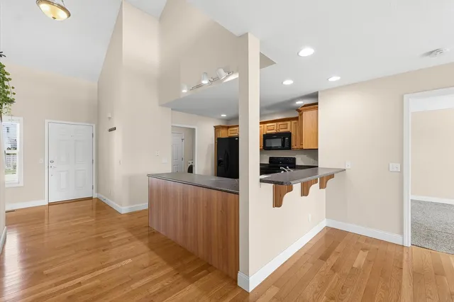 a view of kitchen with stainless steel appliances kitchen island wooden floor and window
