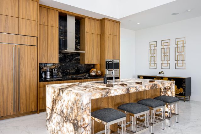 a kitchen with stainless steel appliances kitchen island granite countertop a stove and a sink