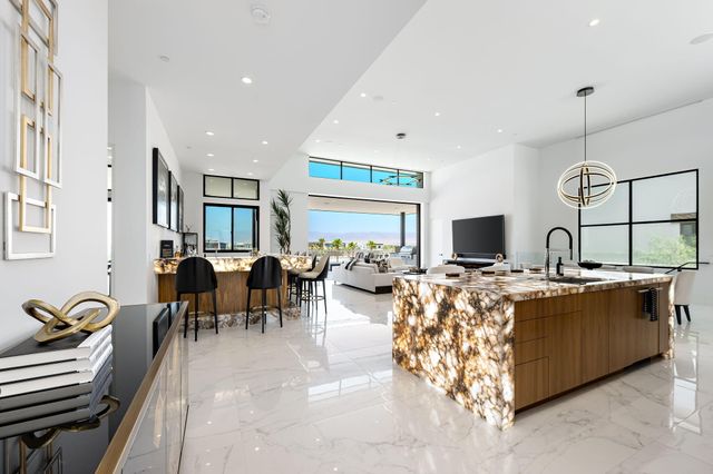 a living room with furniture a flat screen tv and a chandelier