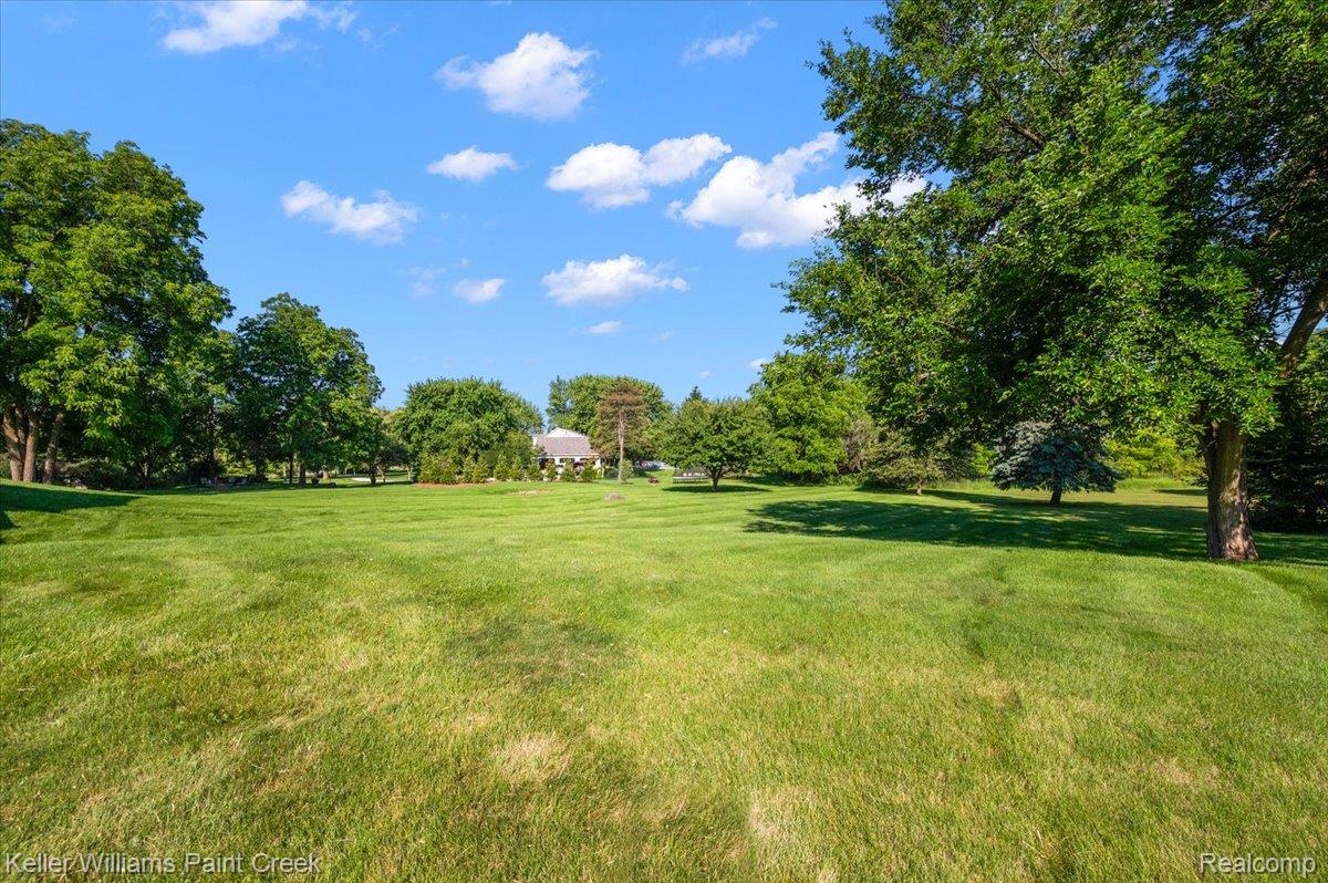 69069 Campground Road Romeo, MI 48065 - Photo 13 of 78 Expansive green lawn with mature trees and distant residential architecture