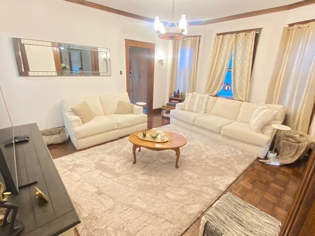 a living room with furniture and a chandelier