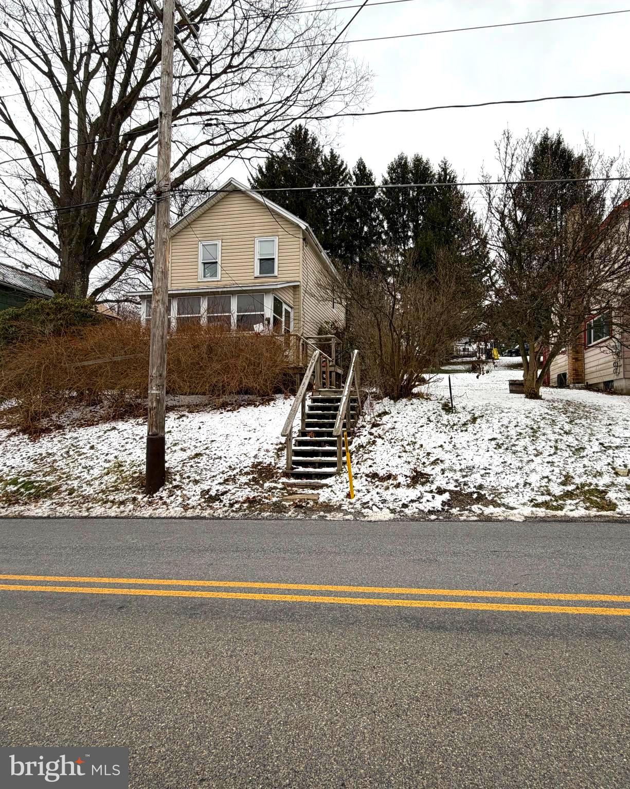 a front view of a house with a yard covered with snow