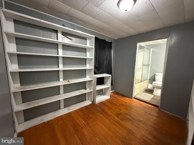 a room with a bed and a view of kitchen