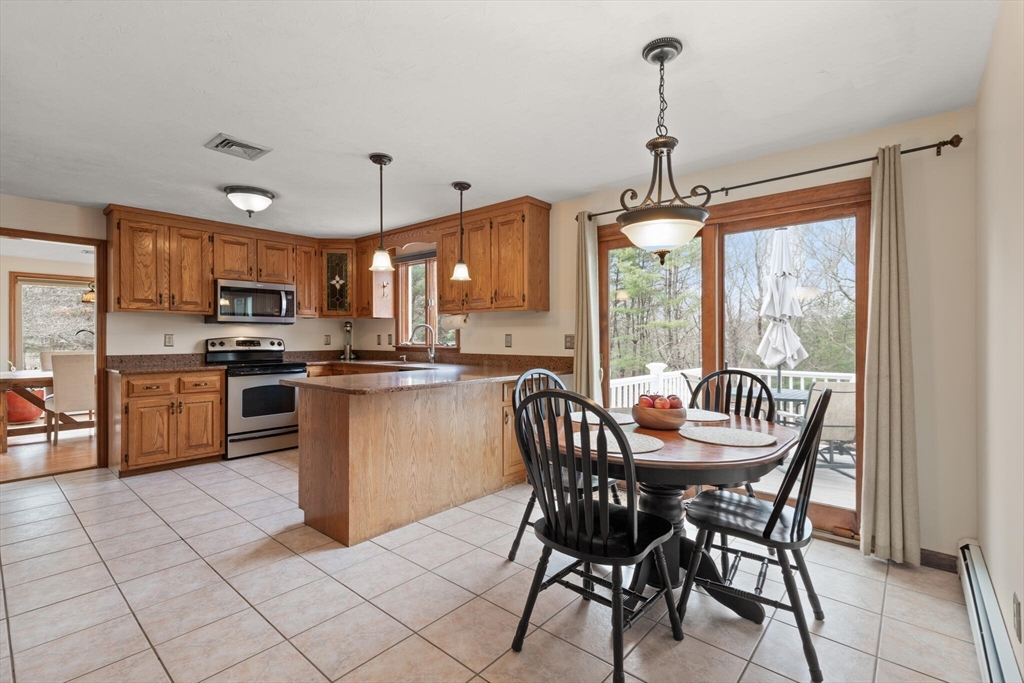 3 Daniels Road Mendon, MA 01756 - Photo 11 of 42 a kitchen with stainless steel appliances granite countertop a stove top oven a sink dishwasher a dining table and chairs with wooden floor