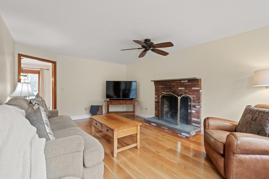 3 Daniels Road Mendon, MA 01756 - Photo 18 of 42 a living room with furniture a fireplace and a flat screen tv