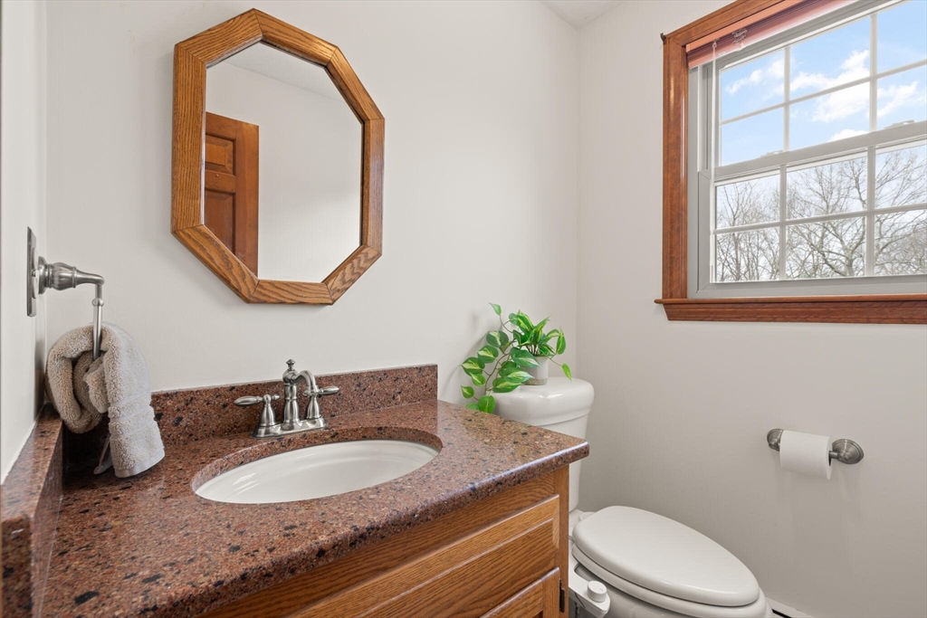3 Daniels Road Mendon, MA 01756 - Photo 20 of 42 a bathroom with a granite countertop toilet a sink and a mirror