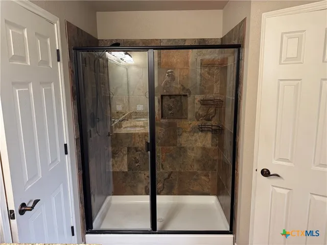 a bathroom with a glass shower door