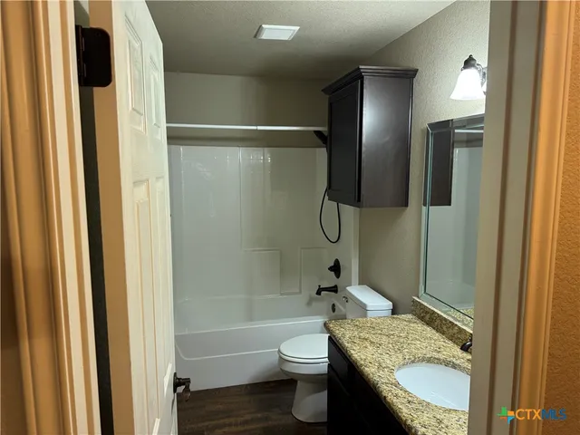 a bathroom with a granite countertop toilet sink and shower