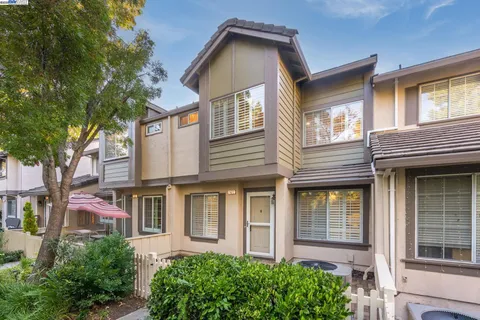 a view of a brick house with large windows and a large tree