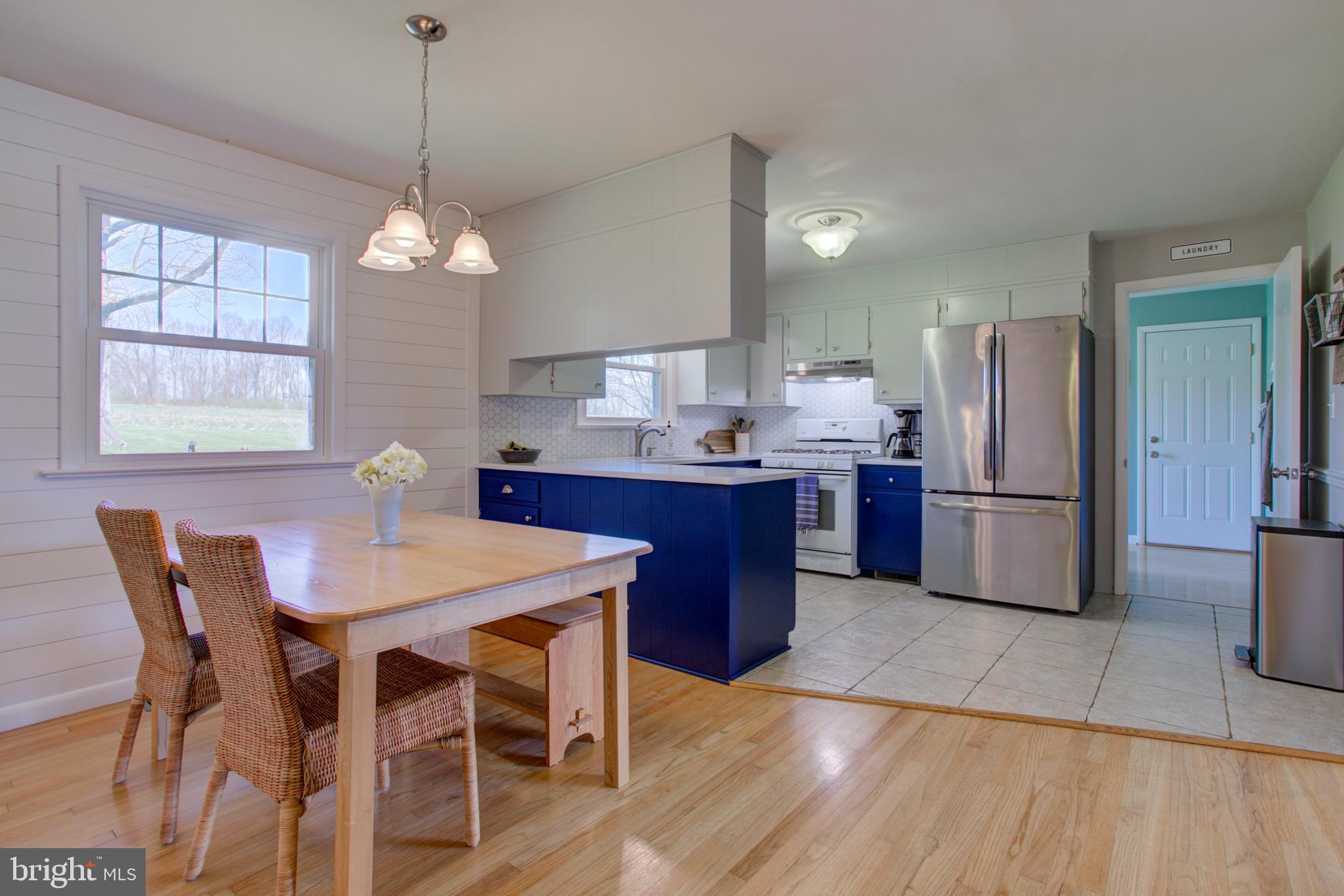 1853 Rockvale Road Lancaster, PA 17602 - Photo 11 of 43 a kitchen with stainless steel appliances granite countertop a refrigerator a stove a sink dishwasher a dining table and chairs with wooden floor