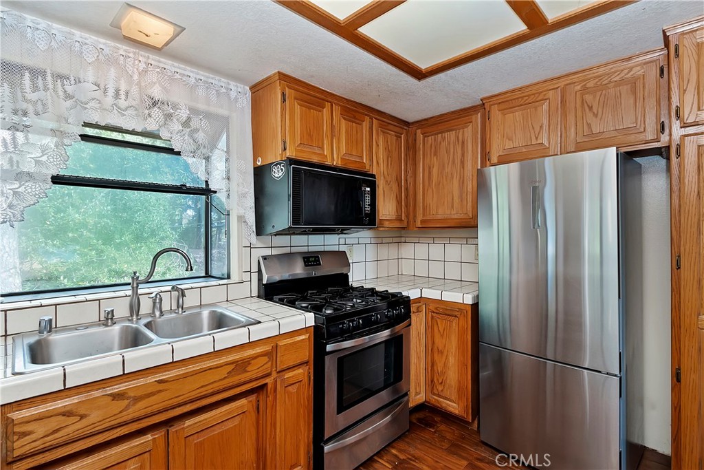 23919 Inspiration Crestline, CA 92325 - Photo 11 of 43 a kitchen with stainless steel appliances granite countertop a refrigerator stove and microwave