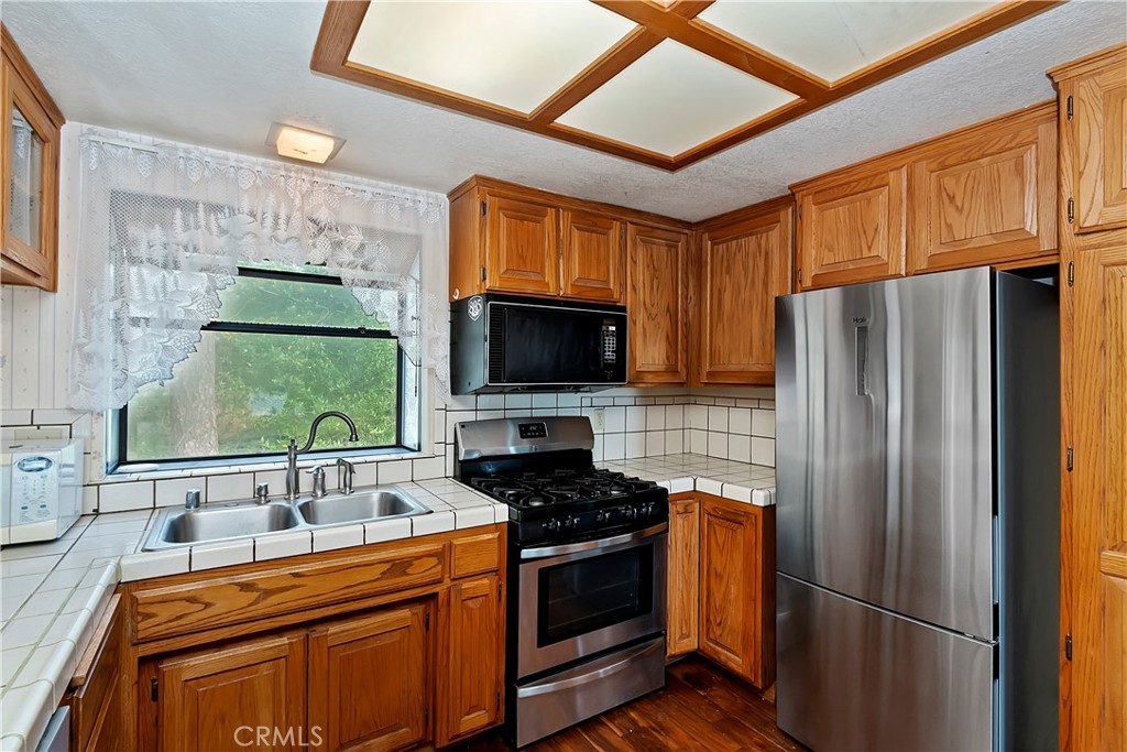 23919 Inspiration Crestline, CA 92325 - Photo 12 of 43 a kitchen with stainless steel appliances a refrigerator stove and sink