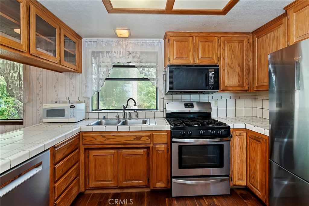23919 Inspiration Crestline, CA 92325 - Photo 9 of 43 a kitchen with stainless steel appliances a stove sink microwave and cabinets