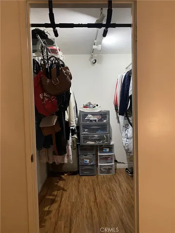 a view of walk in closet with clothes and shoes