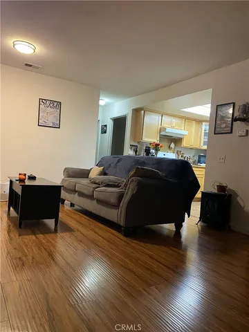 a living room with furniture and a wooden floor