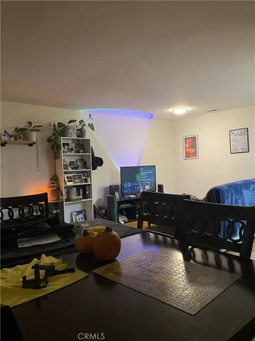 a living room with furniture a flat screen tv and kitchen view