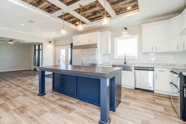 a kitchen with stainless steel appliances granite countertop a sink a refrigerator and a stove top oven