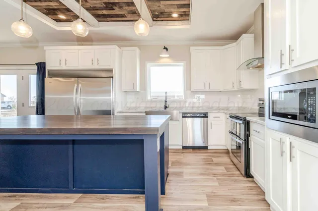 a kitchen with granite countertop a sink stainless steel appliances and cabinets