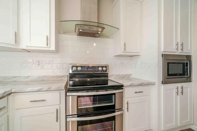 a kitchen with stainless steel appliances granite countertop a stove and a wooden floors