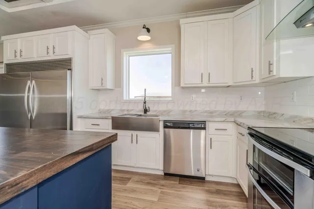 a kitchen with granite countertop stainless steel appliances and wooden cabinets
