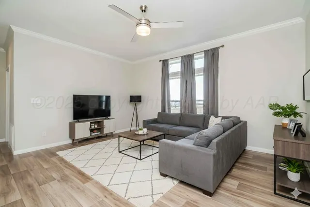 a view of a room with wooden floor and a ceiling fan