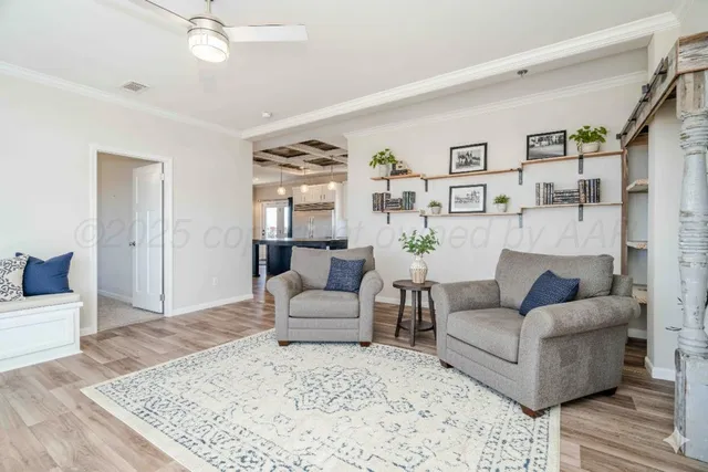 a view of empty room with wooden floor and fan