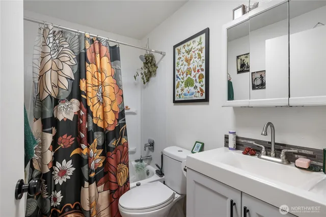 a bathroom with a sink a toilet and shower curtain