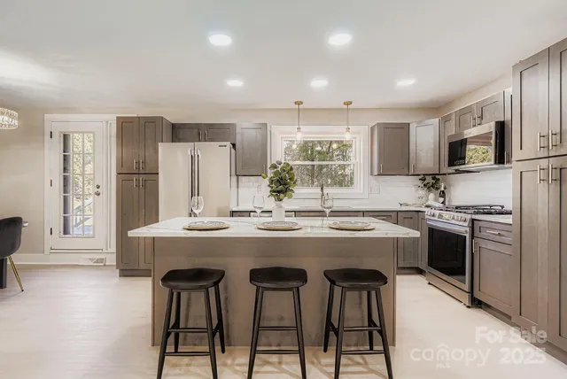 a kitchen with kitchen island granite countertop a sink and stainless steel appliances