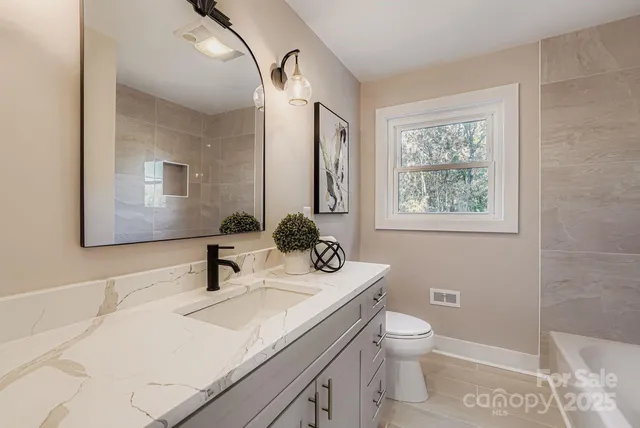 a bathroom with a sink toilet and mirror