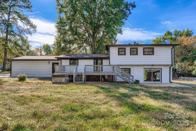a view of a house with a yard patio and a tree